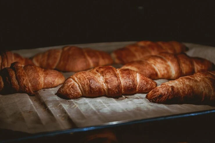 Golden croissants resting on a baking tray